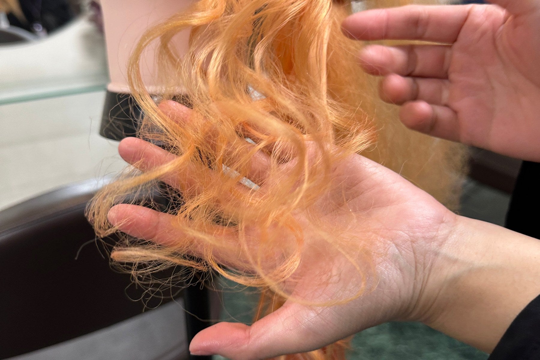 Hands lifting a curled section to check the finished movement